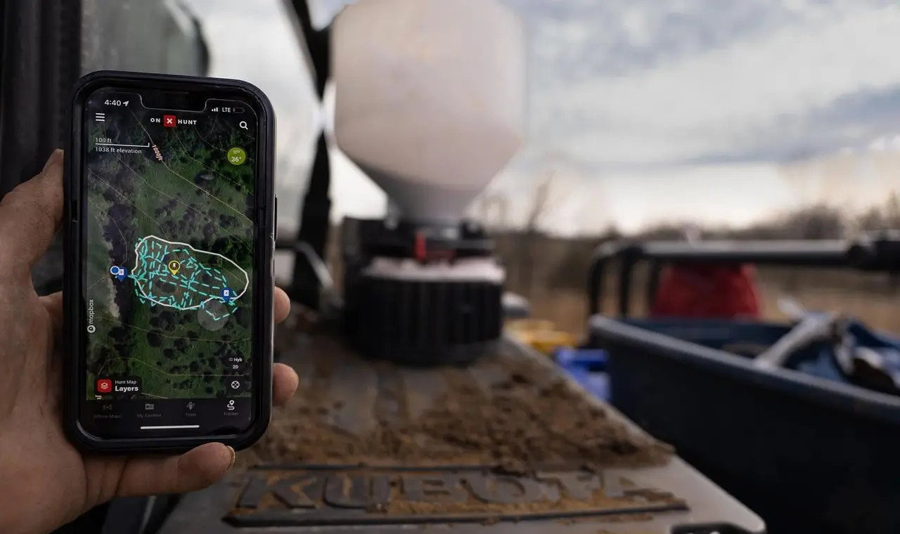 Marking a whitetail property plan on an onX Hunt map from the tailgate of a UTV