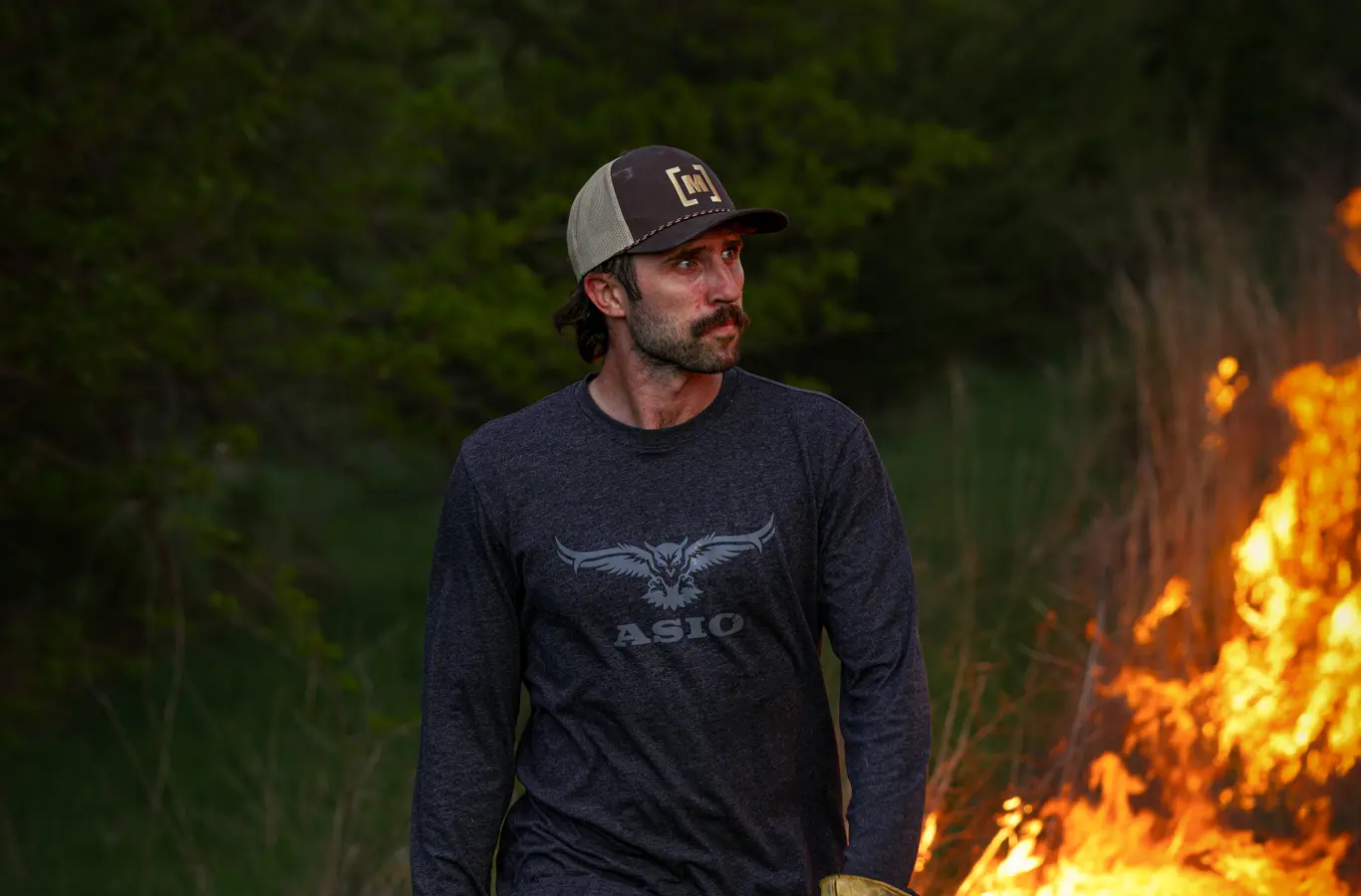Kaleb Greiner watching a prescribed burn move through cover on an Iowa property